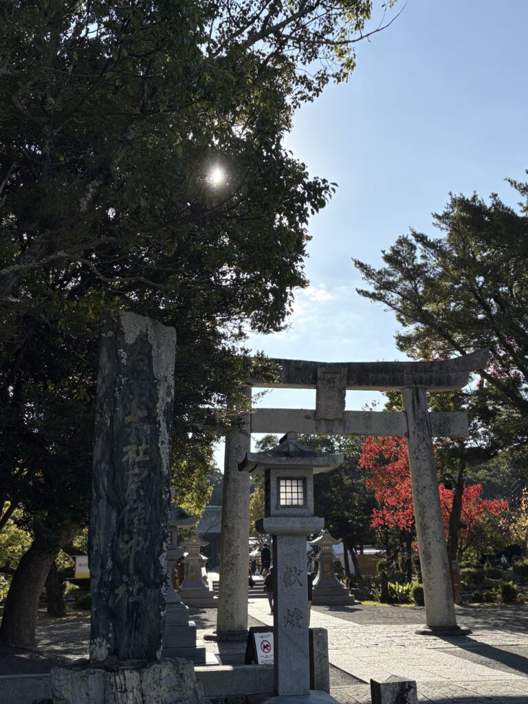 宗像大社の入口に立つ鳥居。背後に色づいた紅葉が広がる秋の景色