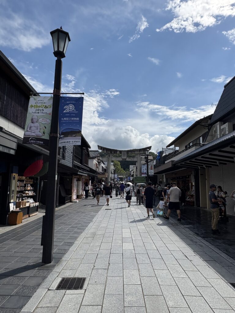太宰府天満宮参道の風景。鳥居へと続く石畳の道の両側に土産店や飲食店が並び、多くの観光客で賑わっている
