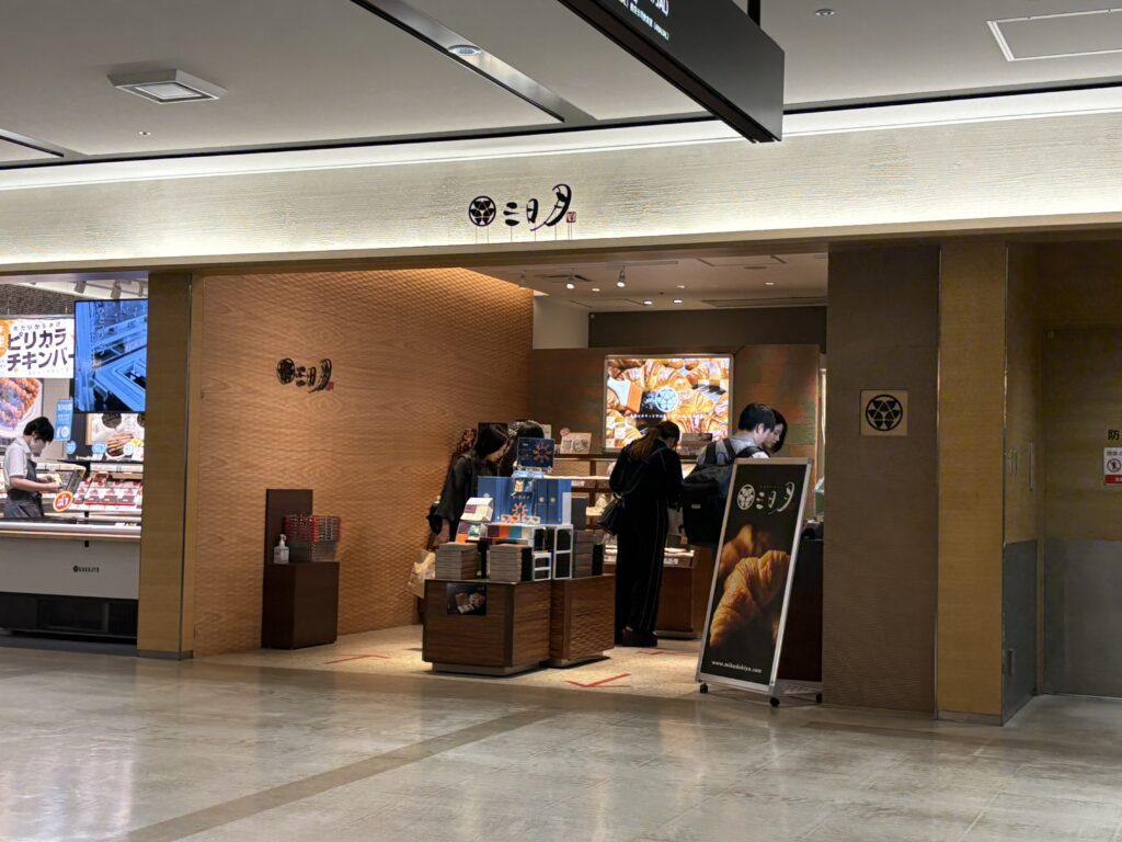 「福岡空港『三日月屋』店舗外観。天然酵母クロワッサンが人気の福岡発おみやげ店。」。