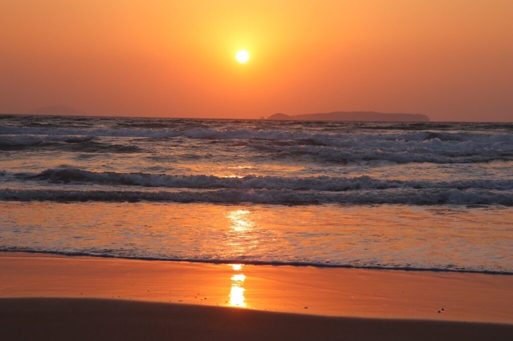 太陽が海に沈む瞬間。福間海岸の波打ち際がオレンジに輝く美しいサンセット