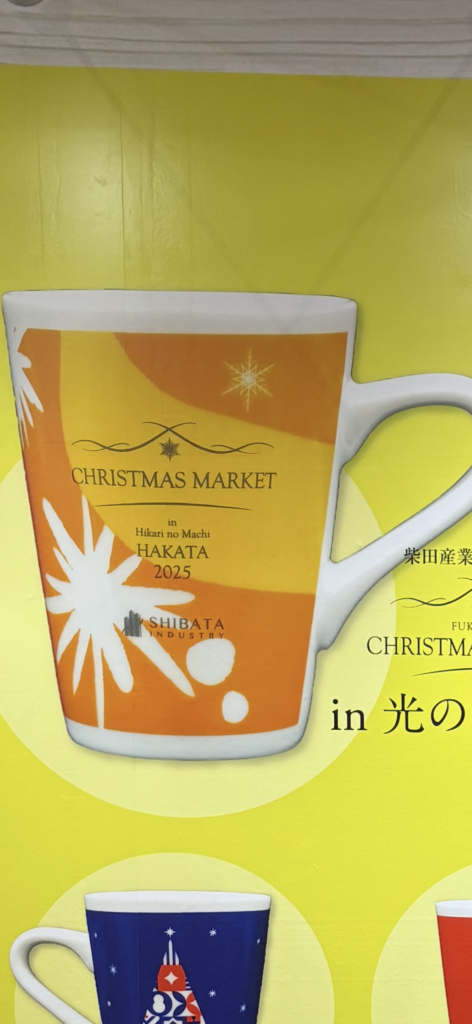 福岡・光の街 博多クリスマスマーケットのオレンジ色のマグカップ。雪の結晶が描かれた2025年デザイン